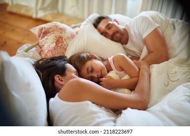 Family Snuggle Time. Shot Of A Family Sleeping In Bed At Home.