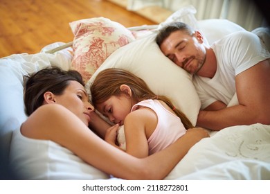 Family Snuggle Time. Shot Of A Family Sleeping In Bed At Home.