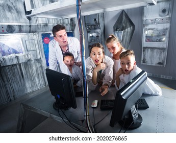 Family Is Solving Puzzles On Computer In Escape Room Stylized Like Laboratory.