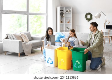 Family sorting garbage in recycle bins at home - Powered by Shutterstock