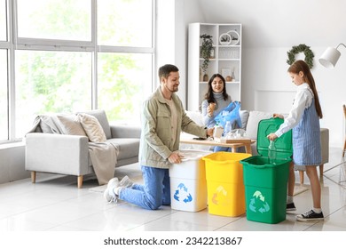 Family sorting garbage in recycle bins at home - Powered by Shutterstock