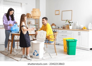 Family sorting plastic garbage with recycle bin in kitchen - Powered by Shutterstock