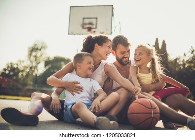 Family spending time together. Family on basketball playground.  