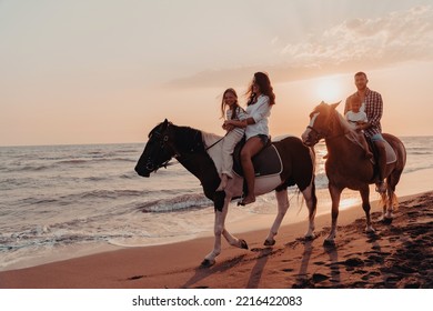 The family spends time with their children while riding horses together on a sandy beach. Selective focus  - Powered by Shutterstock