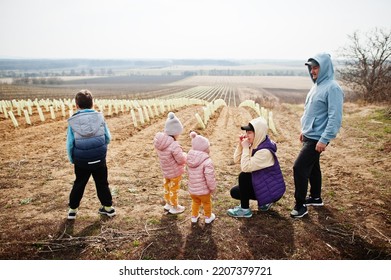 Family Stand Against Vineyard In Early Spring.