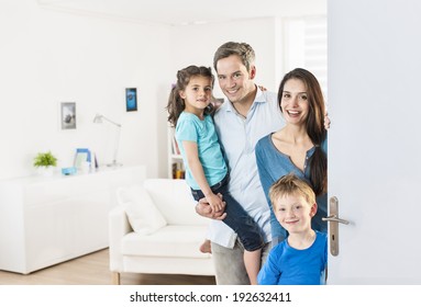 Family standing at front door to invite people at home