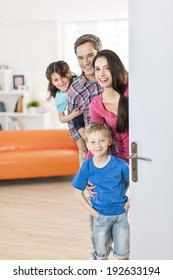 Family Standing At Front Door To Invite People At Home