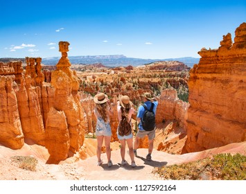 Family Standing Next To Thor's Hammer Hoodoo On Top Of  Mountain Looking At Beautiful View. Bryce Canyon National Park, Utah, USA