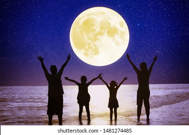 Family Standing On Beach And Watching The Moon.Celebrate Mid Autumn Festival Together