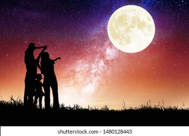 family standing on hill and watching the moon.Celebrate Mid-autumn festival together