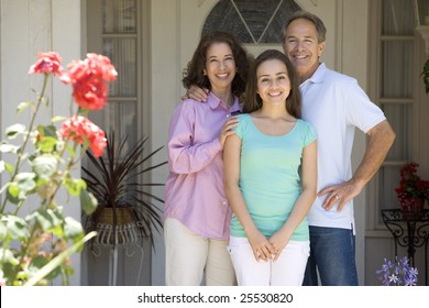 Family Standing Outside House