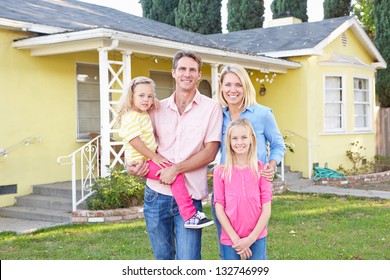 Family Standing Outside Suburban Home