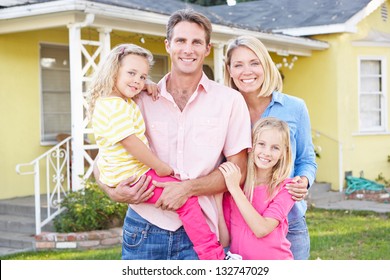 Family Standing Outside Suburban Home