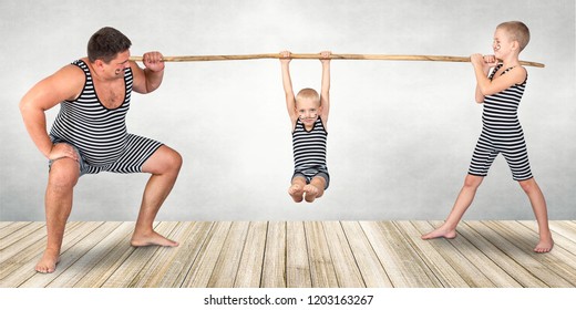 Family Of Strongman. The Father Of Two Sons In Vintage Costume Of Athletes Perform Strength Exercises. Family Look.