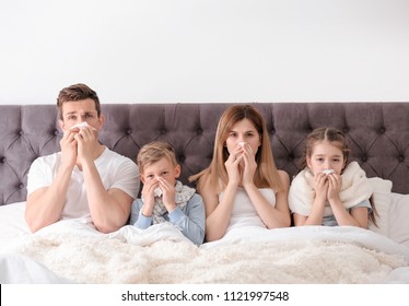 Family suffering from cold in bed at home - Shutterstock ID 1121997548