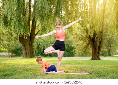 Family Summer Outdoor Sport Activity. Young Caucasian Mother With Child Toddler Boy Doing Workout Yoga Fitness In Park. Woman Mom Doing Physical Exercises Together With Little Kid Outside.