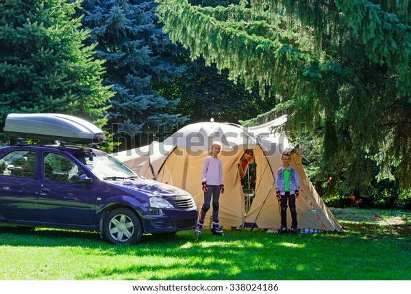Family summer vacation in the coniferus forest with\
a tent.