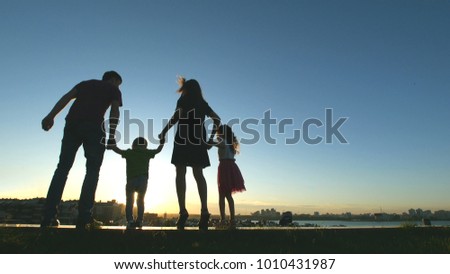 Family at sunset - father, mother, daughter and little son together - silhouette