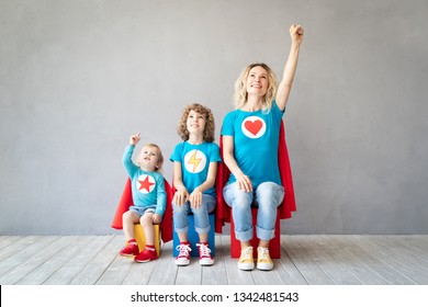 Family Of Superheroes Playing At Home. Mother, Daughter And Son Having Fun Together. Parent With Children Pretend To Be A Super Heroes. Mother's Day Concept