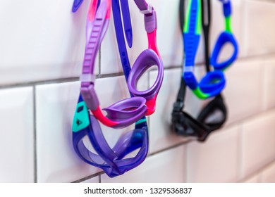 Family Of Swimming Goggles Hanging On A Tiled Wall