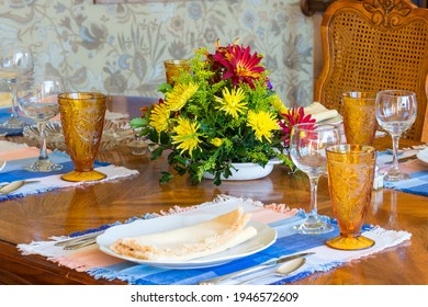 A Family Table Set For A Holiday Or Special Occasion. Place Settings Of Vintage China And Crystal With A Colorful Flower Arrangement Decorate An Old Fashioned Dining Room.