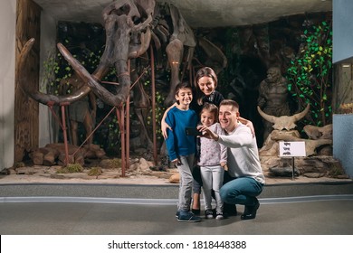 A Family Takes A Selfie Against A Mammoth Skeleton At The Museum Of Paleontology