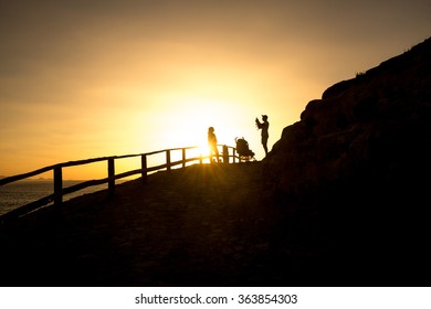 A Family Taking A Picture In The Sunset At The Sea