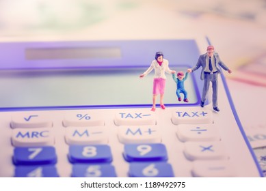 Family Tax Benefit Or FTB / Child Care Fee Concept : Couple Holds A Child On A Calculator, Depicts A Social Security Payment Which Is Distributed To The Parents Or Guardians Of Children Or Teenagers.