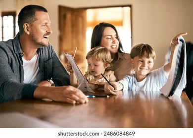 Family, teaching and homework with children, drawing and notepad with proud parents for learning. Kids, home school or study with siblings, mother and father in kitchen for growth or development - Powered by Shutterstock