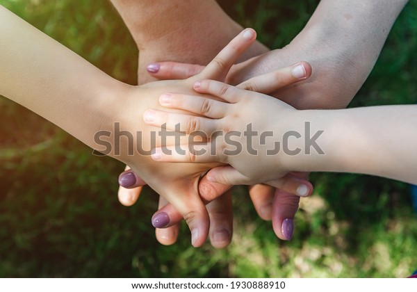 family teamwork, hands on top of each other top\
view, summer sports mood. Close\
up