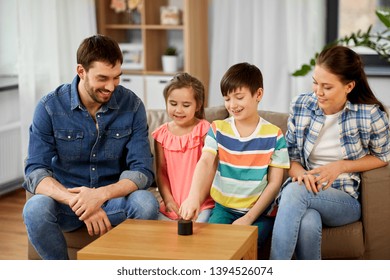 Family, Technology And Internet Of Things Concept - Happy Father, Mother, Little Son And Daughter With Smart Speaker At Home