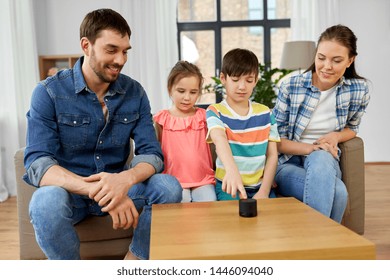 Family, Technology And Internet Of Things Concept - Happy Father, Mother, Little Son And Daughter With Smart Speaker At Home