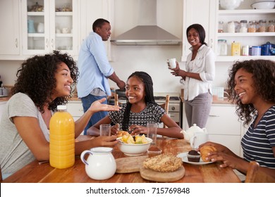 Family With Teenage Children Eating Breakfast In Kitchen