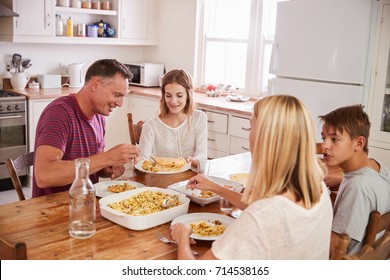 Family With Teenage Children Eating Meal In Kitchen