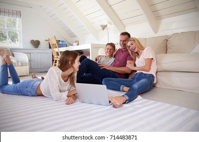 Family With Teenage Children Using Laptop At Home