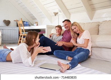Family With Teenage Children Using Technology At Home