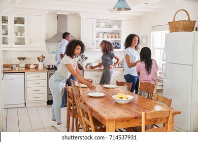 Family With Teenage Daughters Laying Table For Meal In Kitchen - Shutterstock ID 714537931