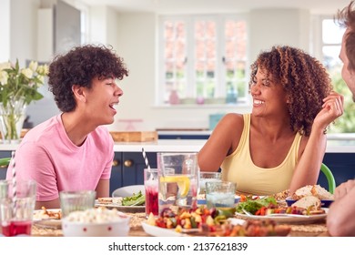 Family With Teenage Son Sitting Around Table At Home Eating Meal Together - Shutterstock ID 2137621839