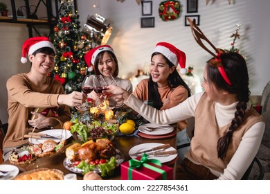 Family at Thanksgiving dinner. Asian Young men and women enjoy roasted turkey and vegetable meal. Asian people group Celebrate Christmas with red wine at home at night. - Powered by Shutterstock