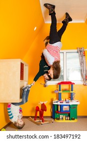 Family Of Three In Children Room Upside Down At Inverted House