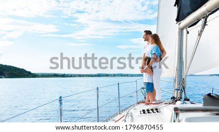 Family Of Three Enjoying Yacht Ride Standing On Boat And Looking At Seascapes Outdoors. Sailing On Vacation. Panorama, Copy Space