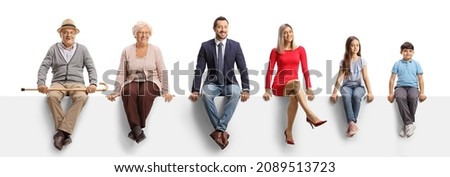 A family of three generations sitting on a blank panel and smiling at camera isolated on white background