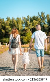 Family Of Three Having Fun On Road Walking Away