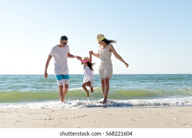 Family Of Three Having Fun On Tropical Beach