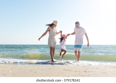 Familia de los tres que se divierten en la playa tropical