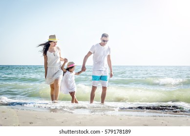 Familia de tres personas en una playa tropical