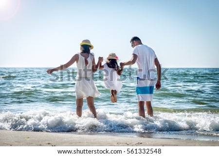 Family of three having fun on tropical beach