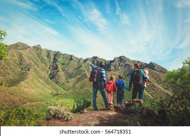 Family With Three Kids Hiking In Mountains