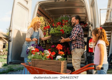 A family of three loading colorful flowers from a wheelbarrow into a delivery van for transport, highlighting their small family business. - Powered by Shutterstock