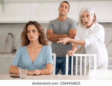 Family of three - mother-in-law, daughter and son quarreling in kitchen - Powered by Shutterstock